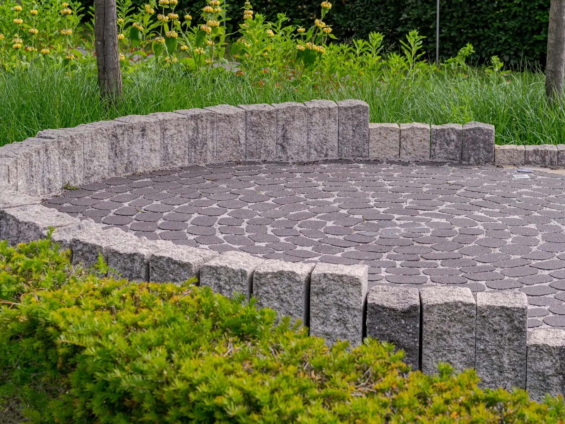 Circular paver patio framed by a stone seat wall