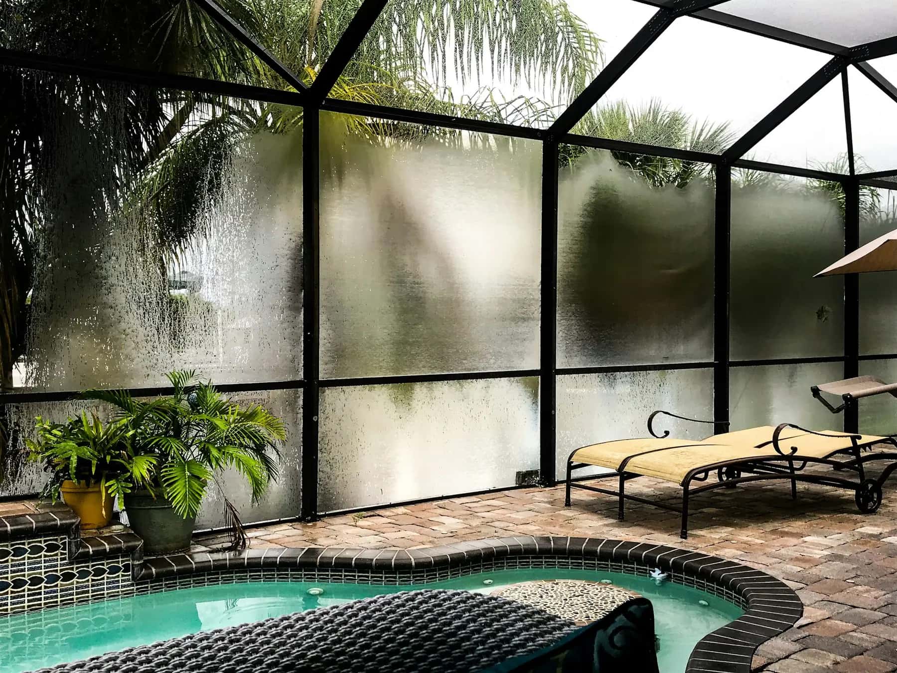 Screened pool enclosure with a brick paver deck