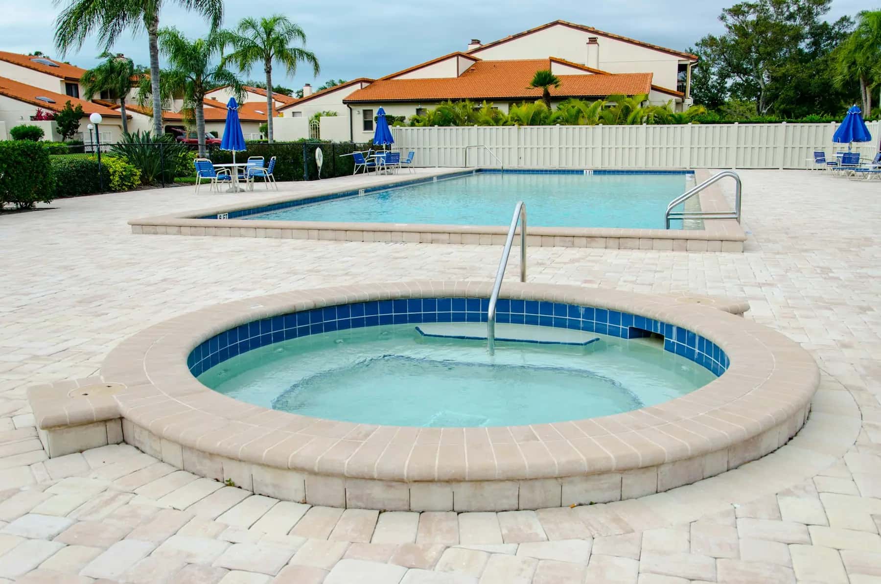 Pool and spa surrounded by a travertine paver deck