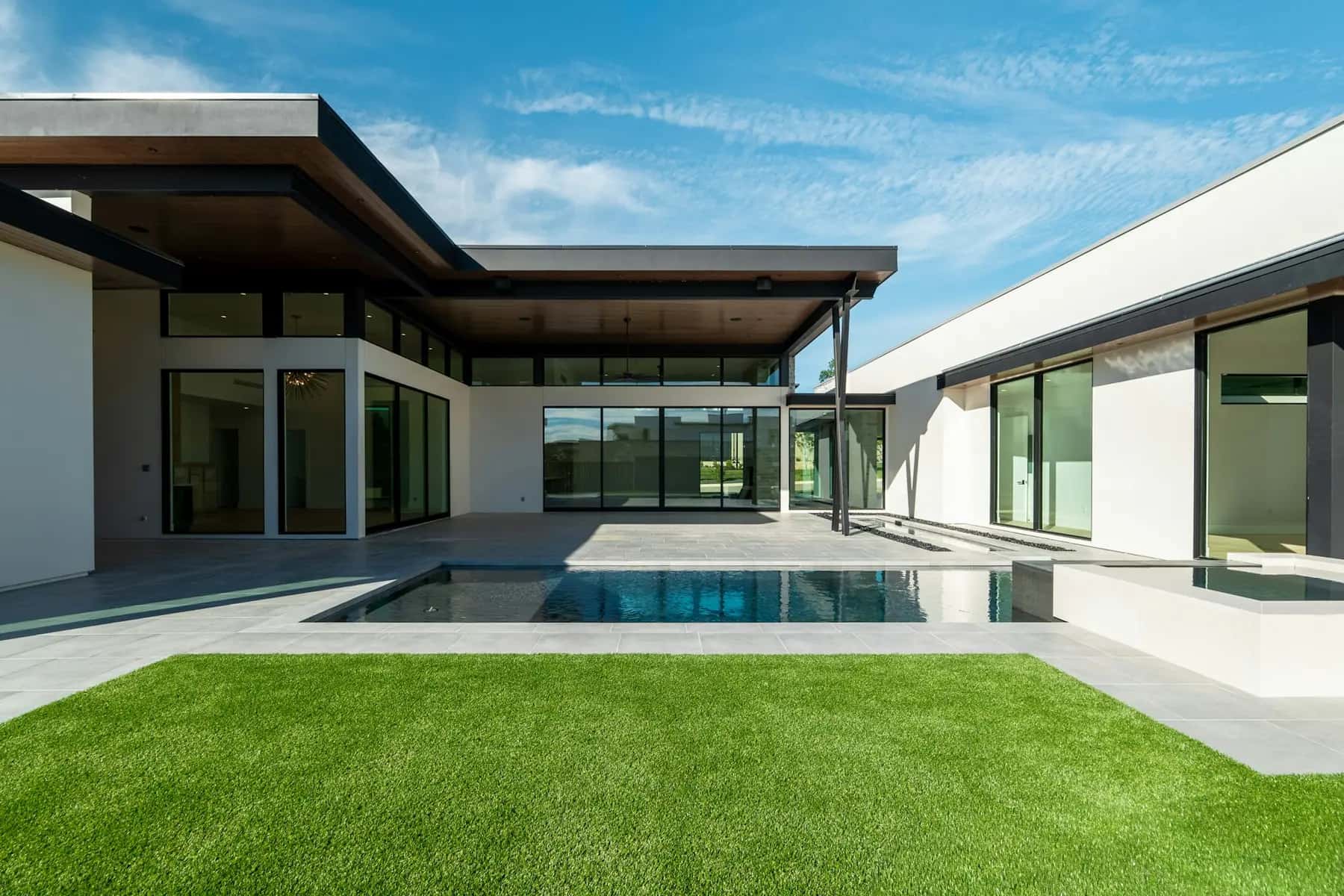Modern home with artificial turf around the pool